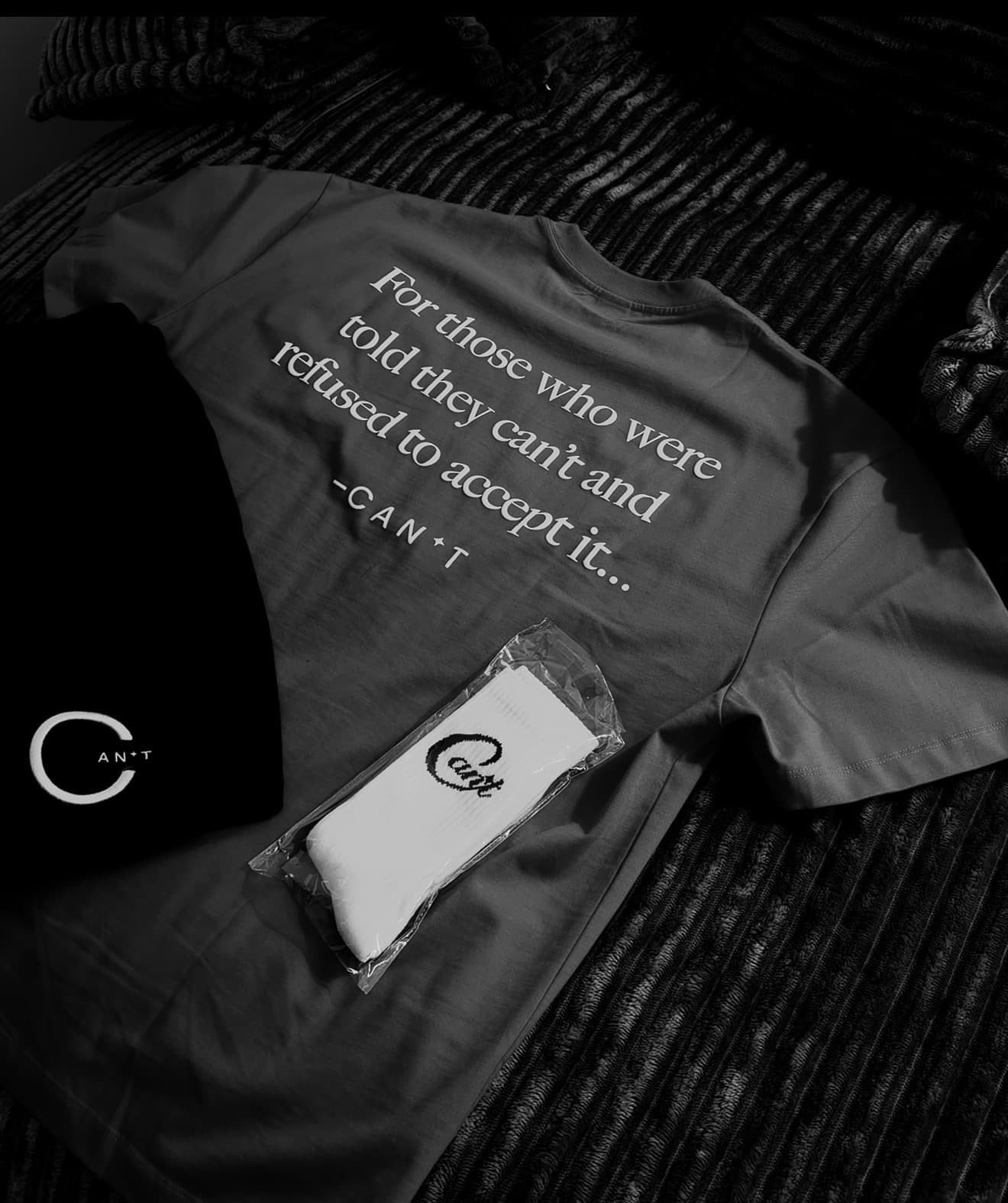 CAN'T apparel laid out: shirt, beanie, and socks.